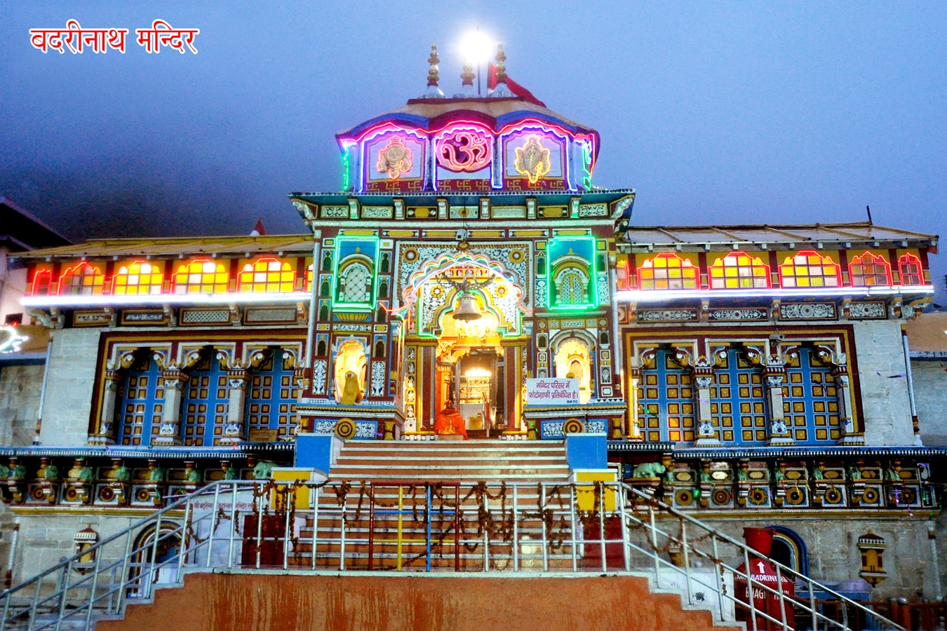 Badrinath Temple surrounded by Garhwal Himalayas with devotees performing prayers